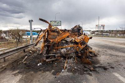 Burnt military vehicles of russian soldiers on the bridge across the river. rusty cars.