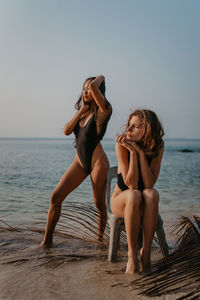 Side view of woman sitting at beach