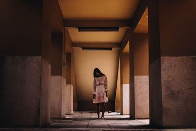 Full length of young woman with halloween make-up standing in corridor