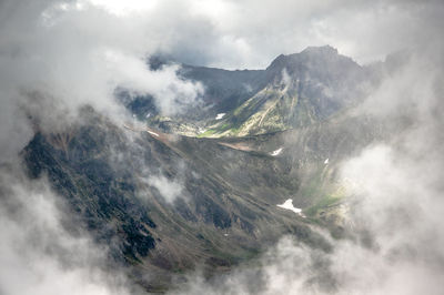 Clouds and fog in summer mountains with green colours