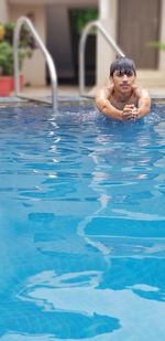 Shirtless young man swimming in pool