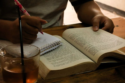 Close-up of hand holding book on table