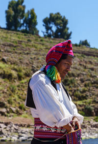 Woman with multi colored standing against sky