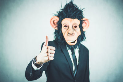 Man wearing monkey mask against white background