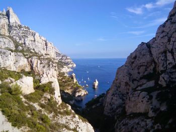 Scenic view of sea and mountains against sky