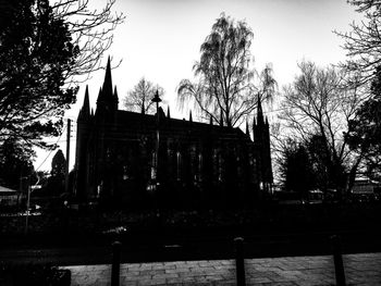 Low angle view of trees and building against sky