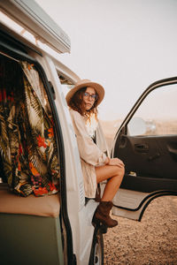 Portrait of woman standing by car