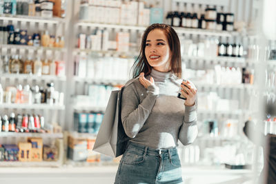 Portrait of a smiling young woman standing in store