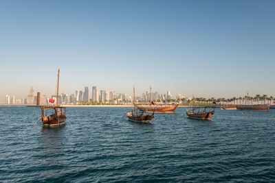 Boats in sea against buildings in city