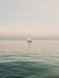 Sailboat sailing on sea against sky