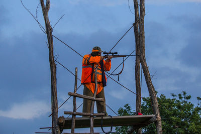 Rear view of hunter against sky