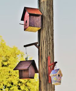Low angle view of birdhouse on wooden house against sky