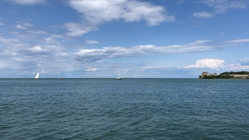 Sailboat sailing on sea against sky