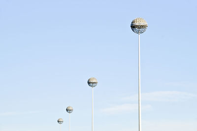 Low angle view of floodlights against sky on sunny day at san siro stadium