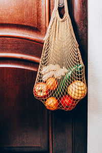 Close-up of orange hanging on table against wall