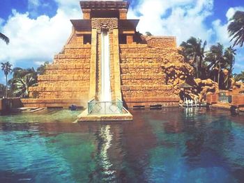 Fountain in front of building against sky