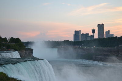 Scenic view of waterfall against sky during sunset