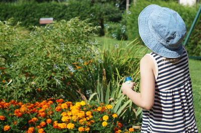 Midsection of woman standing by flowering plants