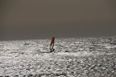 Man surfing in sea against clear sky