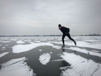 Man skating on ice rink against sky