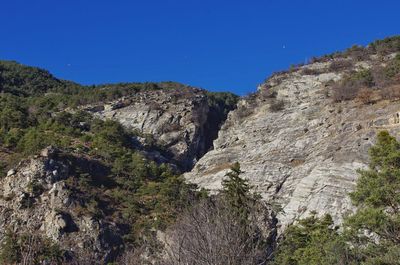 Scenic view of rocky mountains against clear blue sky