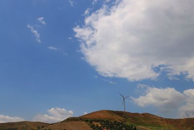 Low angle view of windmill on mountain against sky