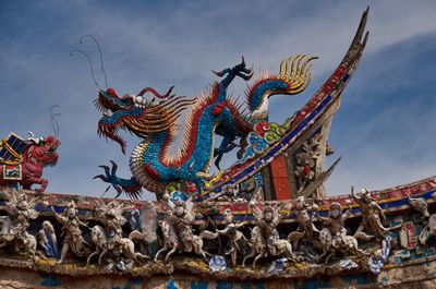 Low angle view of sculptures at manka longshan temple against sky