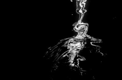 Close-up of water spraying against black background