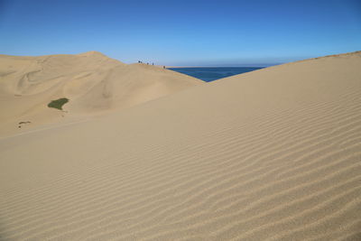 Scenic view of desert against clear blue sky