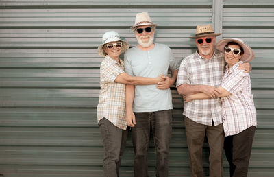 Portrait of couples embracing while standing against shutter