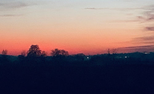 Silhouette trees against sky during sunset