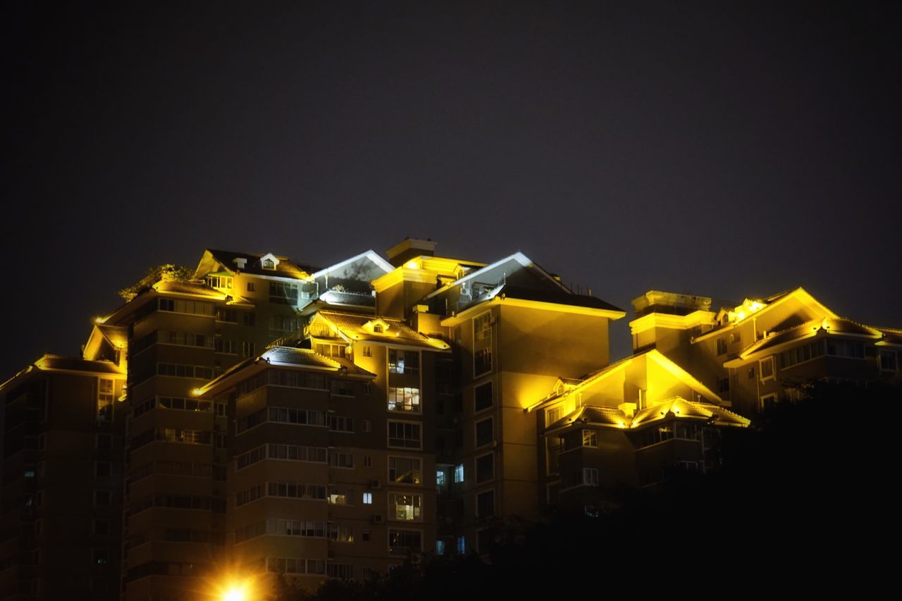 architecture, building exterior, built structure, illuminated, night, city, residential building, low angle view, clear sky, yellow, travel destinations, apartment, sky, outdoors, city life, residential district, facade, no people, tourism, spire, building story