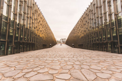 Cobblestone street amidst buildings against sky