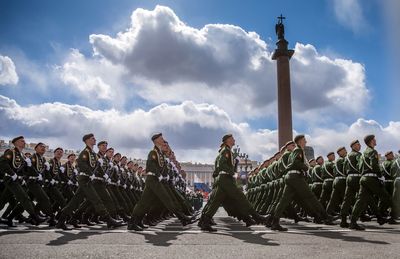 Side view of soldier marching at parade against sky during sunny day