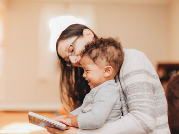 Mother and son reading book at home