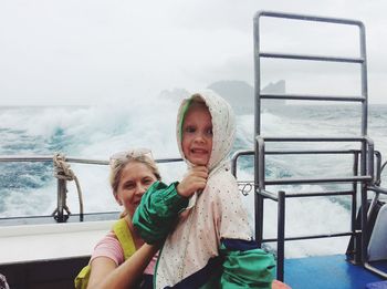 Cheerful people in boat against sky