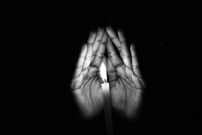 Close-up of man hand against black background