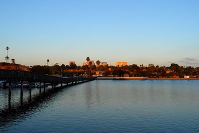 River by buildings against clear sky