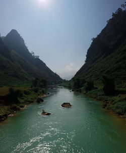 Scenic view of sea and mountains against sky