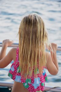 Rear view of girl standing by railing