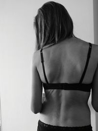 Rear view of woman showing back at home