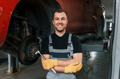 Man in uniform is in the auto service.