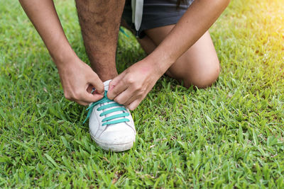 Low section of person wearing shoes on grassy field