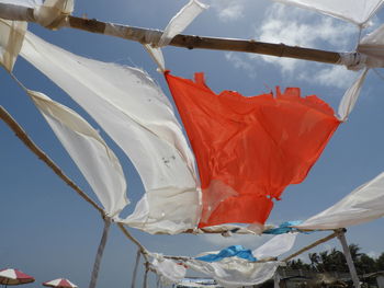 Low angle view of flags hanging on pole against sky