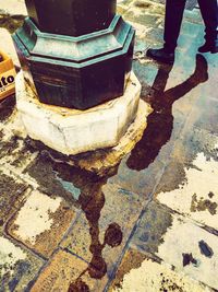 Low section of person standing on street by city