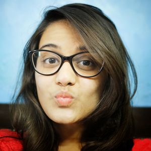 Portrait of young woman puckering against blue wall