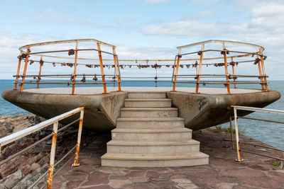 Staircase by sea against sky