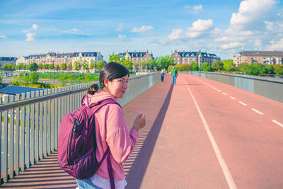 Rear view of woman walking on road against sky