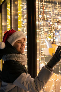 Smiling boy touching glass window of store