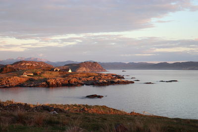 Scenic view of sea and mountains against sky